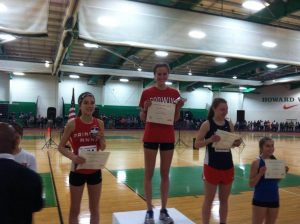 Senior Sarah Goodrich on the podium after placing first in the 3200. Photo courtesy Jon Lauder. 